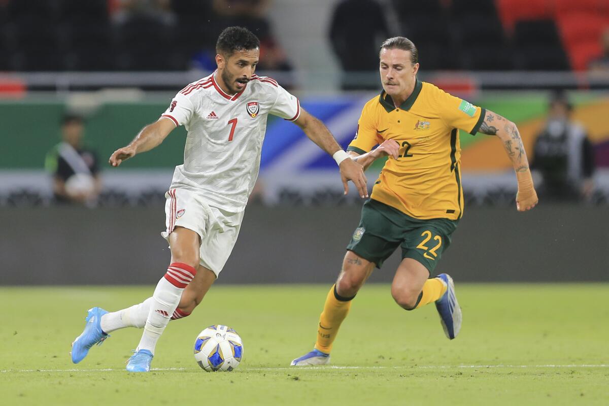 Ali Ahmed of the United Arab Emirates, left, controls the ball in front of Australia's Jackson Irvine.