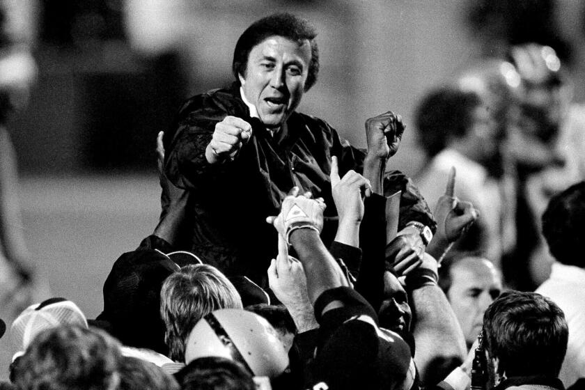 FILE - In this Jan. 23, 1984, file photo, coach Tom Flores gestures to members of the Los Angeles Raiders.