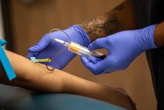 Los Angeles, CA - September 05: Phlebotomist Latrell Anderson, right, draws blood at the Aids Healthcare Foundation Wellness Center - Western on Tuesday, Sept. 5, 2023, in Los Angeles, CA. Los Angeles County's policy related to STD testing is about to change. (Francine Orr / Los Angeles Times)