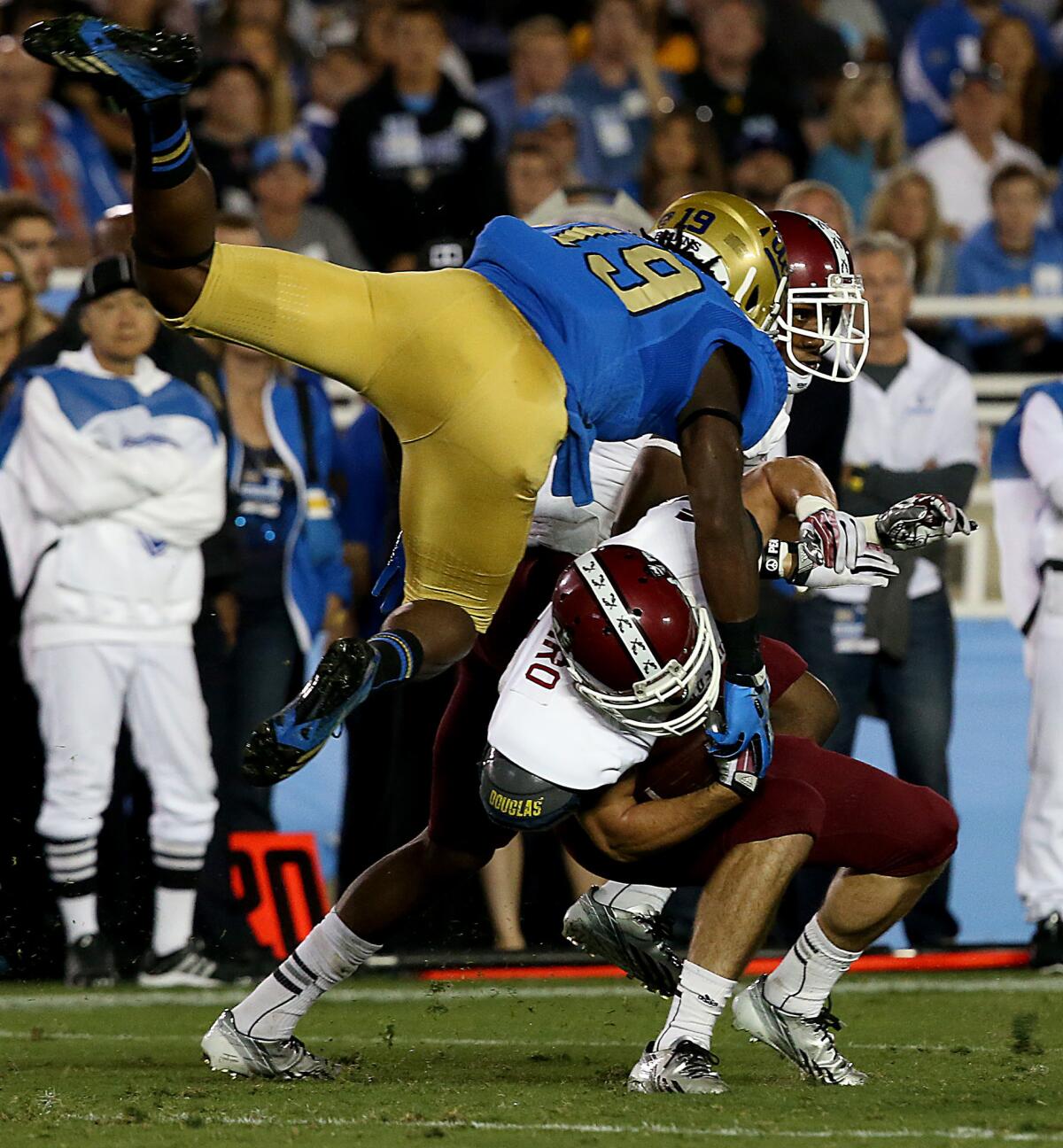 UCLA's Jayon Brown puts a flying hit on New Mexico State kick returner Adam Shapiro on Sept. 21, 2013.