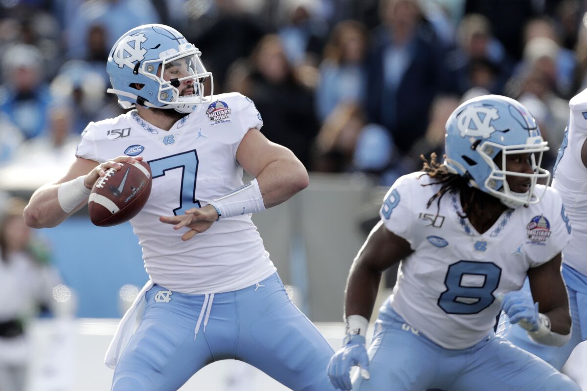 FILE - North Carolina quarterback Sam Howell throws a touchdown pass to wide receiver Dyami Brown during the first half of the Military Bowl NCAA college football game against Temple, Friday, Dec. 27, 2019, in Annapolis, Md. No. 18 North Carolina has plenty of hype with quarterback Sam Howell leading an offense full of returning playmakers for Mack Brown's second season. The Tar Heels open Saturday against Syracuse with a chance to prove the hype is deserved. (AP Photo/Julio Cortez, File)