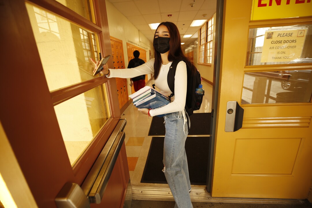 A student carries books in a school hallway