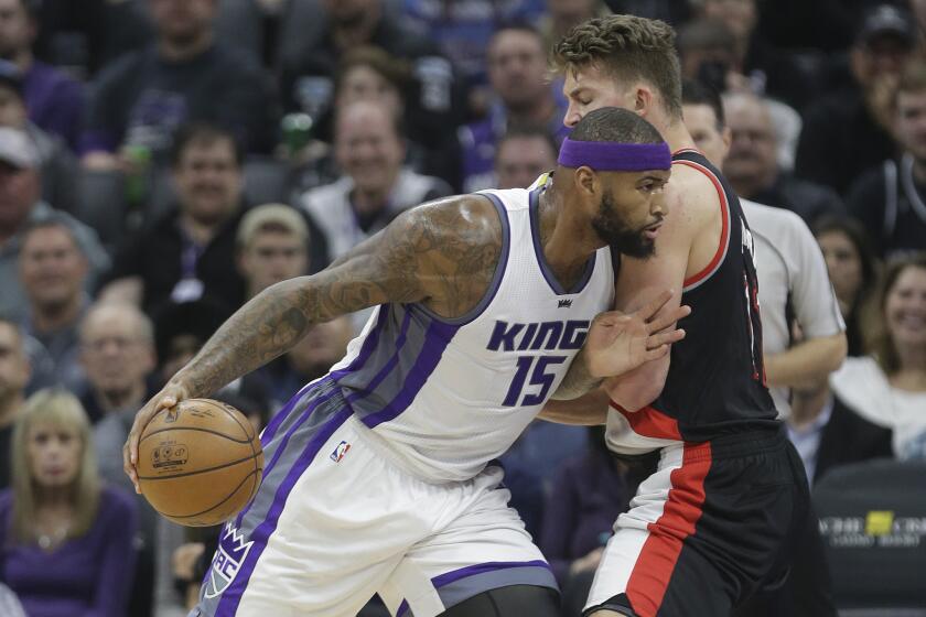 Sacramento Kings forward DeMarcus Cousins, left, goes to the basket against Portland Trail Blazers' Meyers Leonard during the first quarter on Tuesday.