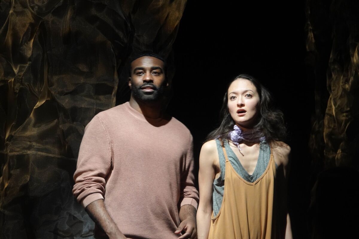 A casually dressed man and woman stand side by side on a stage.