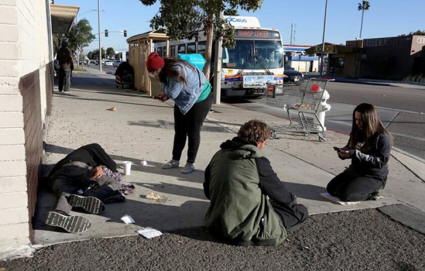 City Net volunteer and licensed vocational nurse Angie Munoz, left, and lead case manager Jennifer Munoz speak with homeless men in the 1800 block of Placentia Avenue in Costa Mesa during last January's Orange County Point in Time count.
