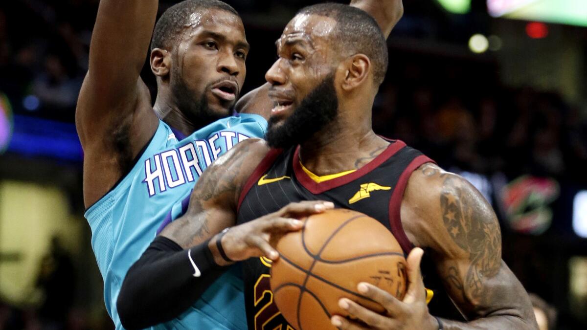 Cavaliers forward LeBron Jame drives past Hornets forward Michael Kidd-Gilchrist during the first half Friday.
