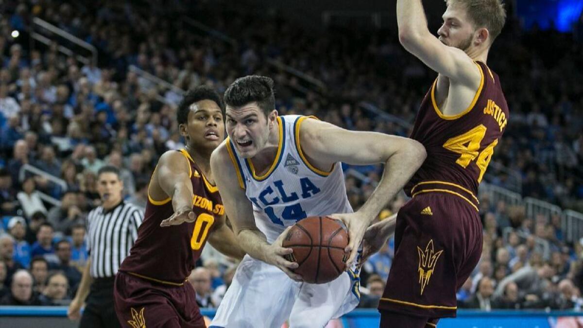 UCLA forward TJ Leaf splits two Arizona State defenders during a game at Pauley Pavilion on Thursday.