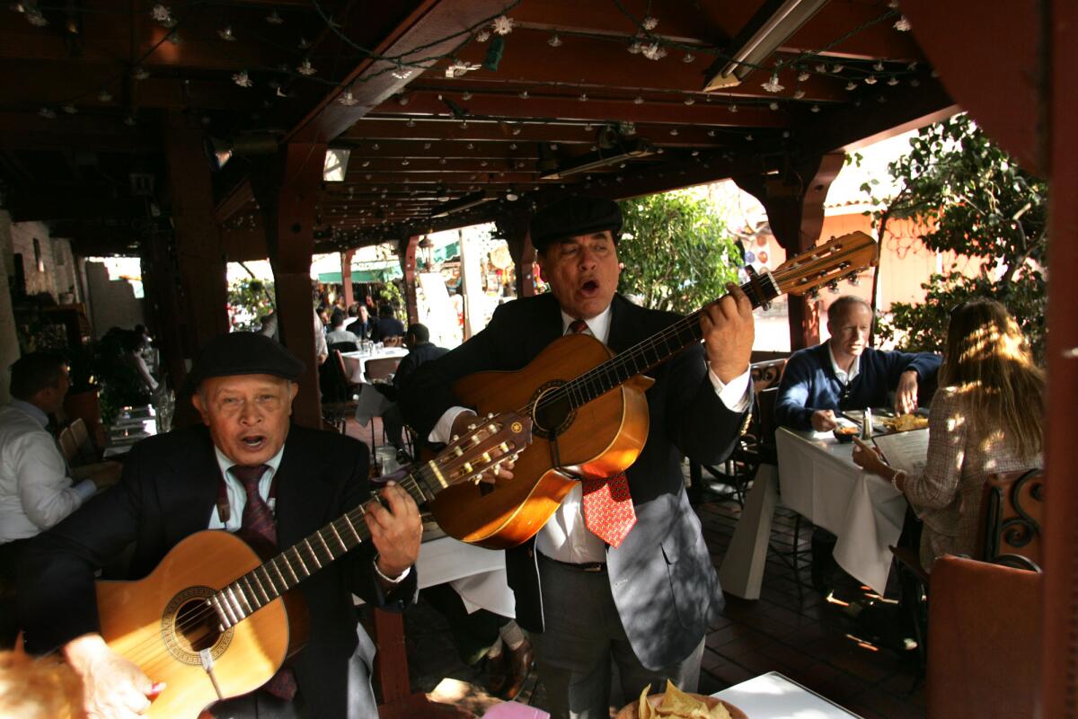 2006 photo of performers singing for patrons of La Golondrina Cafe