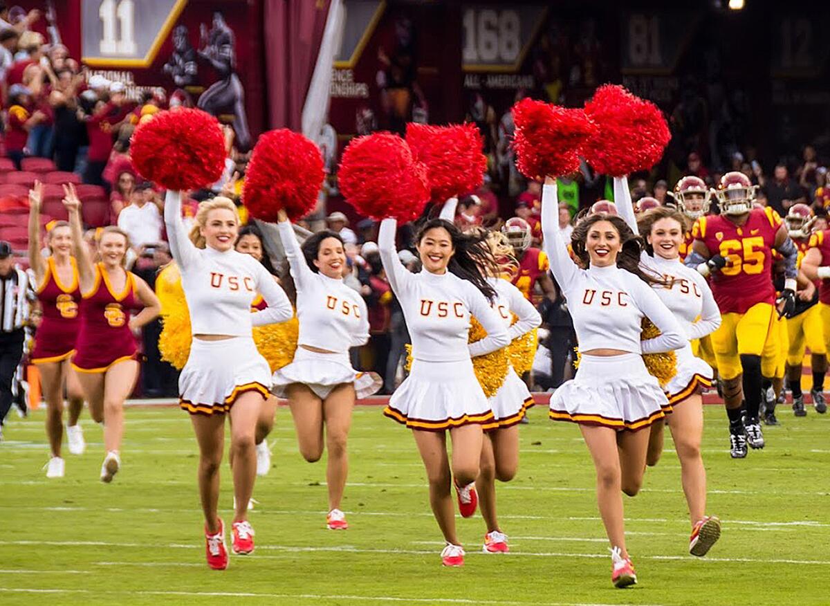 USC song girls run across the football field before a 2019 game against Oregon.