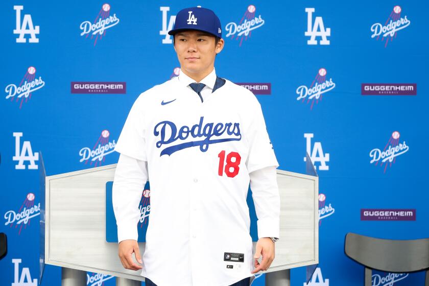 LOS ANGELES, CA - DECEMBER 27: Yoshinobu Yamamoto poses for a photo as he is introduced during a press conference as the newest member of the Los Angeles Dodgers in the centerfield plaza at Dodger Stadium in Los Angeles Wednesday, Dec. 27, 2023. The Japanese right-hander signed a 12-year, $325-million contract to play with the Dodgers. (Wally Skalij / Los Angeles Times)