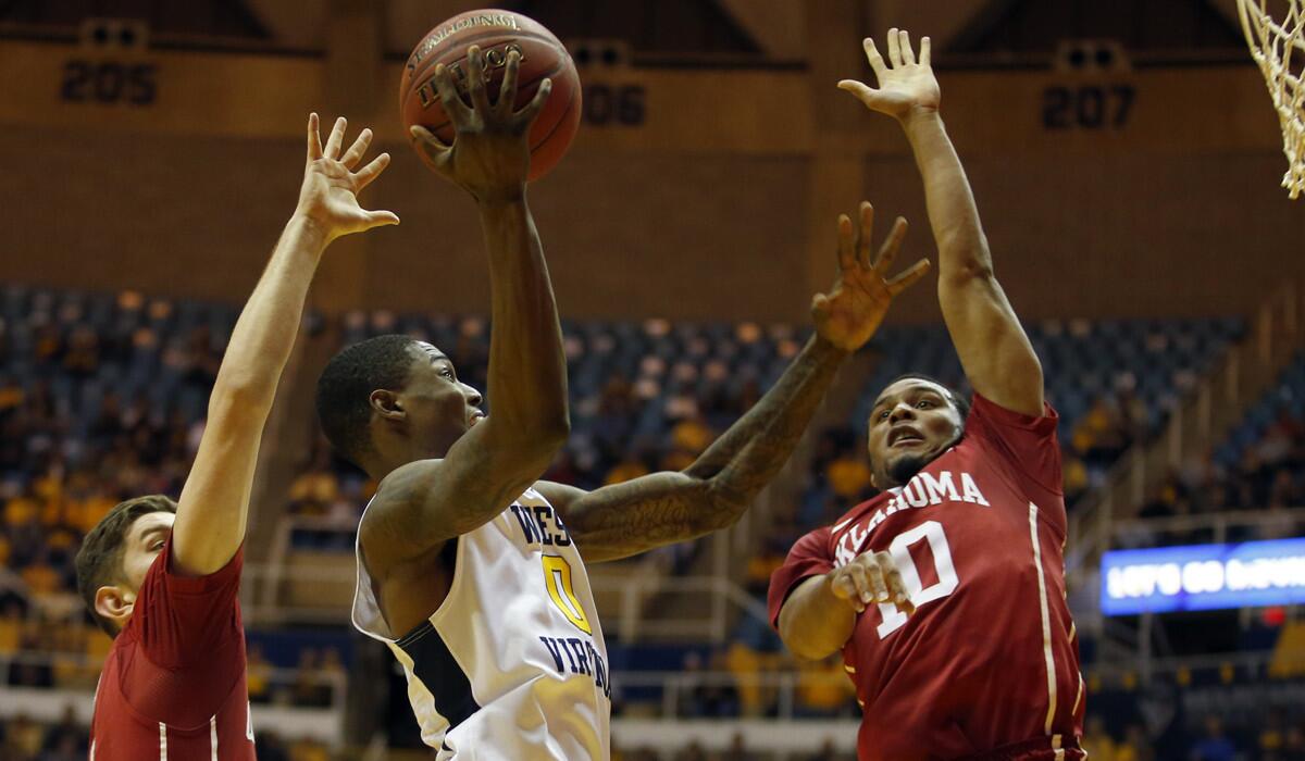 West Virginia's Teyvon Myers (0) drives to the basket against Oklahoma's Jordan Woodard (10) during the game Wednesday.