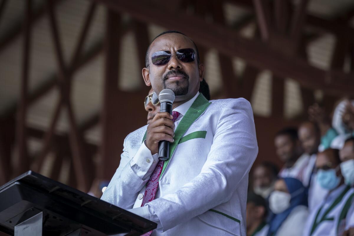 Abiy Ahmed speaks into a microphone before a crowd