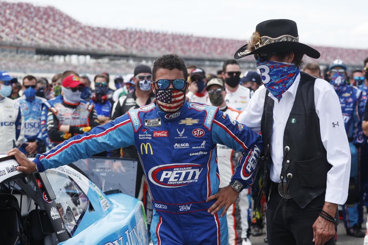 Team owner Richard Petty, right, stands with driver Bubba Wallace.