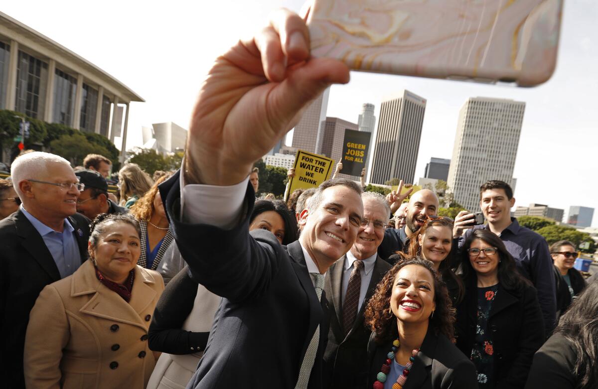 Mayor Eric Garcetti takes a selfie with Aura Vásquez, a former Department of Water and Power commissioner, after announcing in February that the city wouldn't rebuild three gas-fired power plants. The decision has drawn protests and an ad campaign from the DWP union.