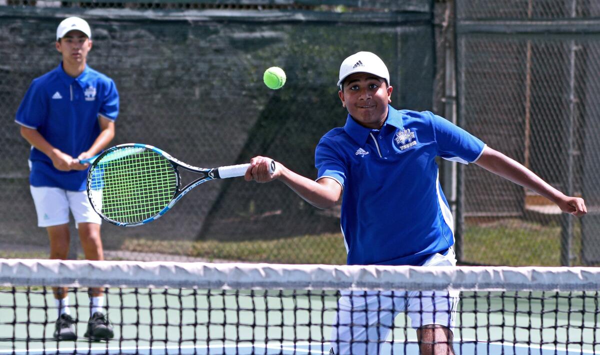 Fountain Valley's Vivek Savsani returns the ball as partner Ben Nguyen looks on in the round of 32 doubles match in the CIF Southern Section Individuals tournament against Cypress at Seal Beach Tennis Center on Wednesday.