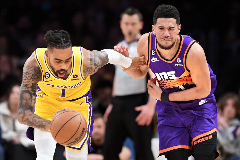Los Angeles, California March 22, 2023-Lakers D'Angelo Russell steals the ball away from Suns Devin Booker in the fourth quarter at Crypto.com arena Wednesday. (Wally Skalij/Los Angeles Times)