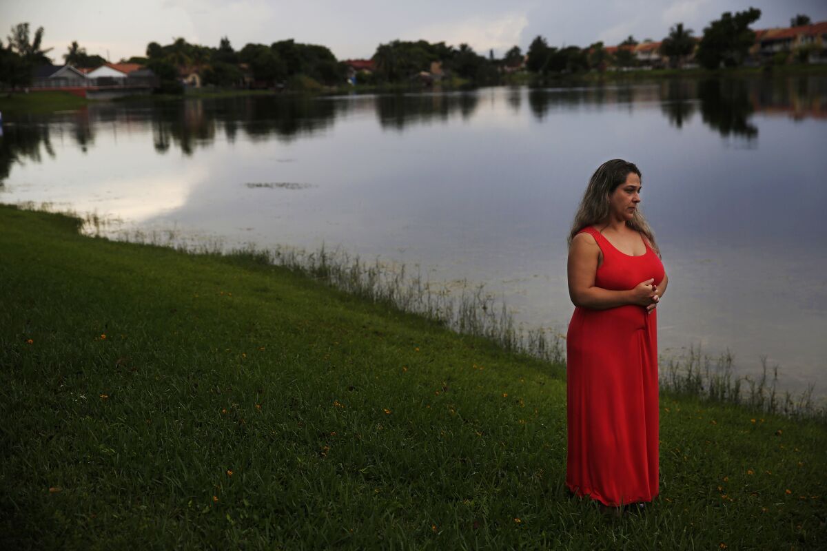 In this Aug. 6, 2019, photo, Barbara Rodriguez poses for a photo outside of her home in Hialeah, Fla. Her husband, Pablo Sanchez, is seeking asylum in the U.S., but was placed in detention and is now facing deportation to Cuba. (AP Photo/Brynn Anderson)