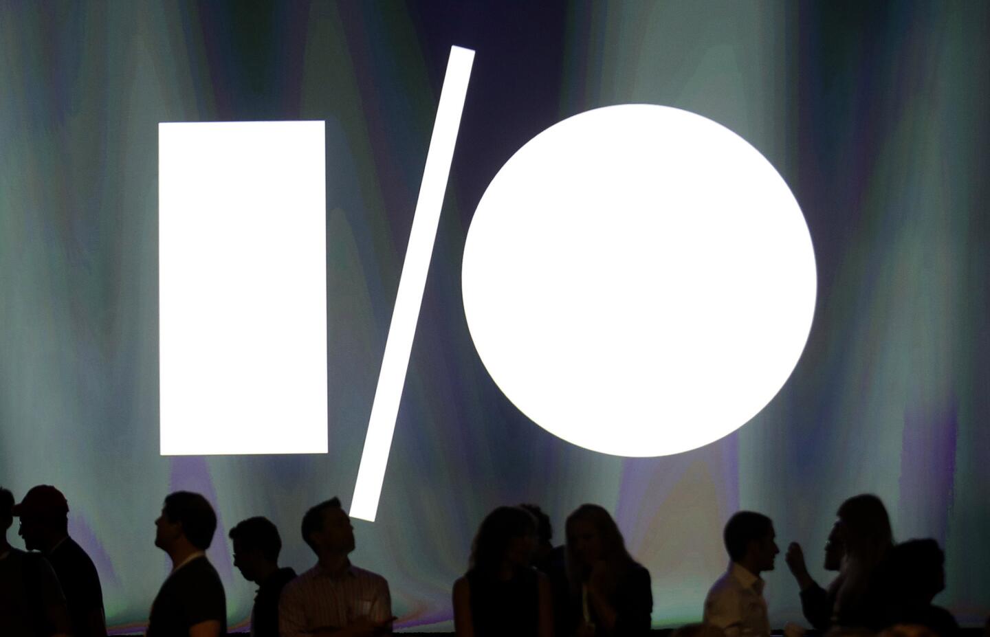 Attendees at the Google I/O 2014 keynote presentation stand in front of display screen at the Moscone Center in San Francisco.