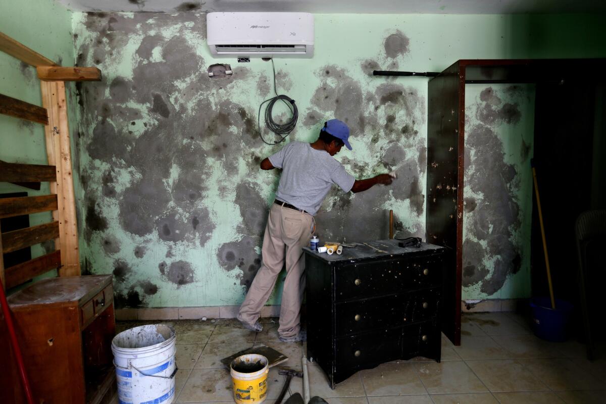 A worker spackles the walls after a deadly shootout in Los Cabos, Mexico, in 2017.