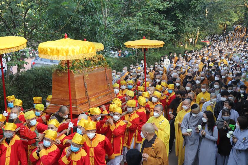 Coffin of Vietnamese Buddhist monk Thich Nhat Hanh is carried to the street during his funeral in Hue, Vietnam Saturday, Jan. 29, 2022. A funeral was held Saturday for Thich Nhat Hanh, a week after the renowned Zen master died at the age of 95 in Hue in central Vietnam. (AP Photo/Thanh Vo)