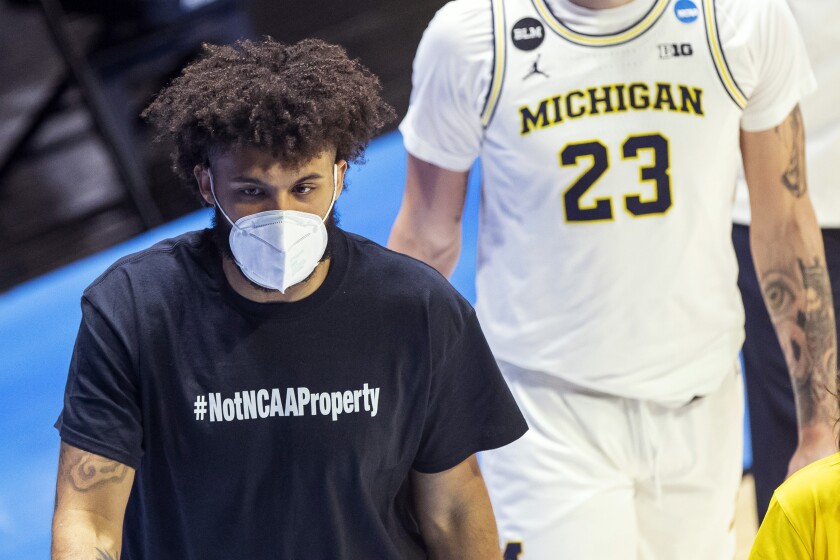 Michigan's Isaiah Livers wears a T-shirt that reads "#NotNCAAProperty" as he walks off the court with teammates after the first half of a first-round game against Texas Southern in the NCAA men's college basketball tournament, Saturday, March 20, 2021, at Mackey Arena in West Lafayette, Ind. (AP Photo/Robert Franklin)