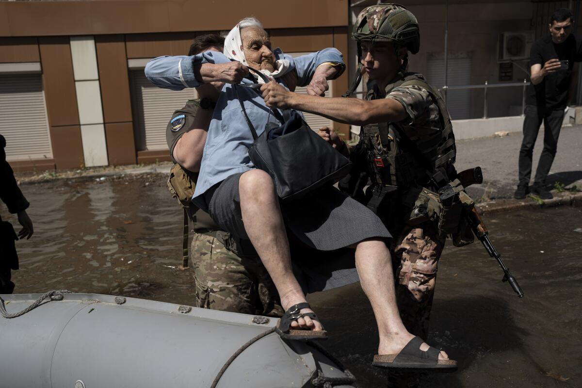 Rescuer carrying woman from flooded area