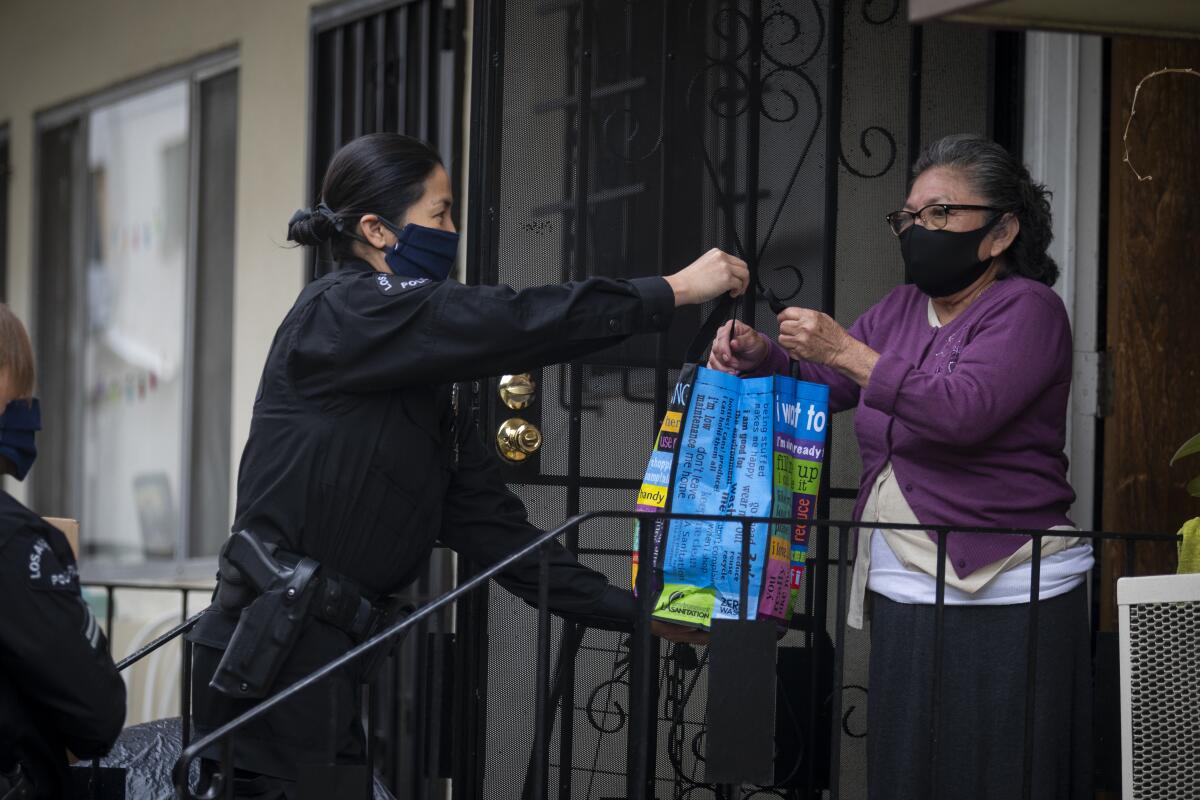LAPD Officer Kat Piamonte delivers food to Donata Ek in Hollywood, on Thursday.