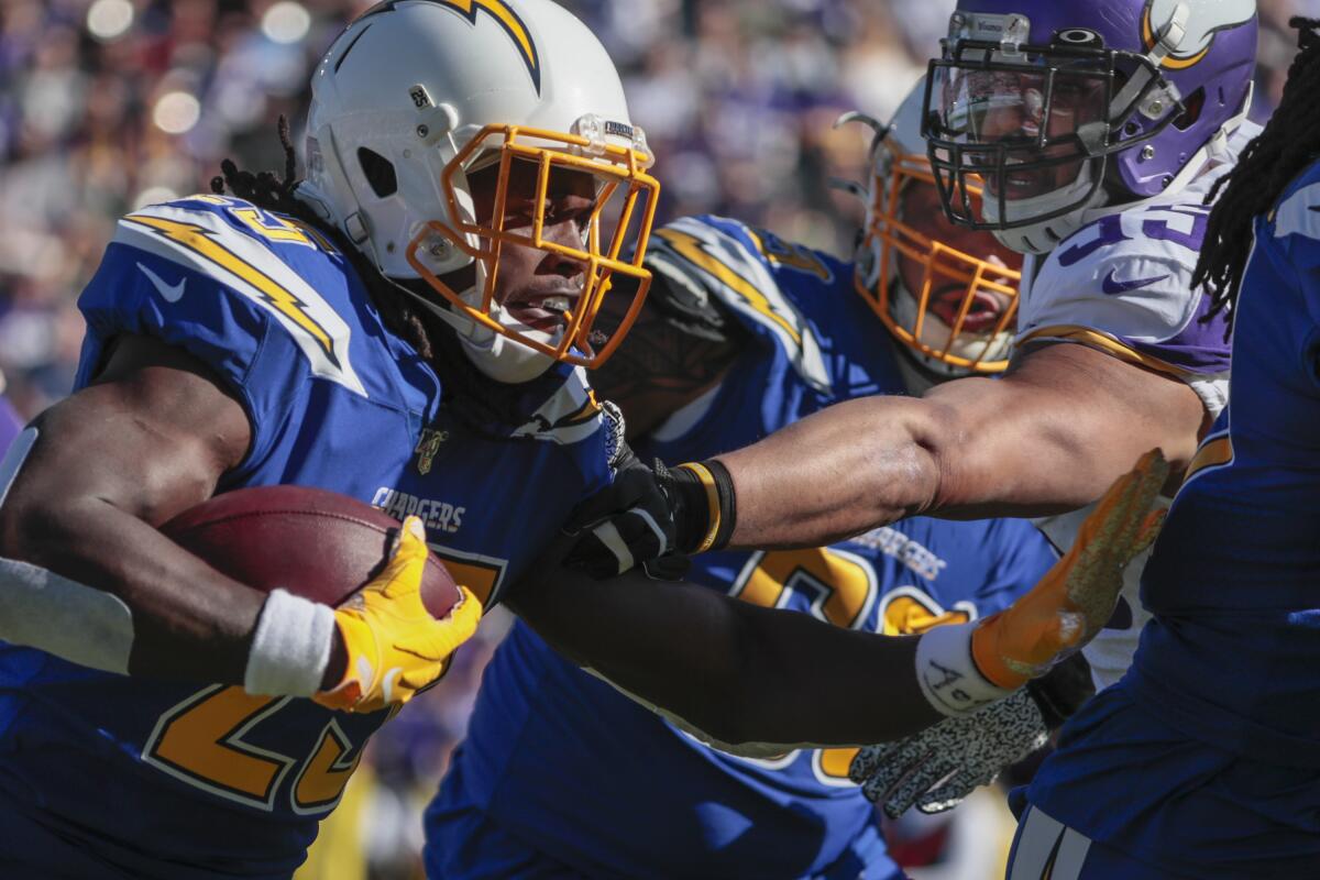 Chargers running back Melvin Gordon (25) rushes past Minnesota Vikings outside linebacker Anthony Barr (55) during a first half drive at Dignity Health Sports Park on Sunday.