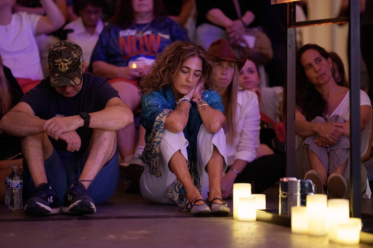 People sit near lighted candles.