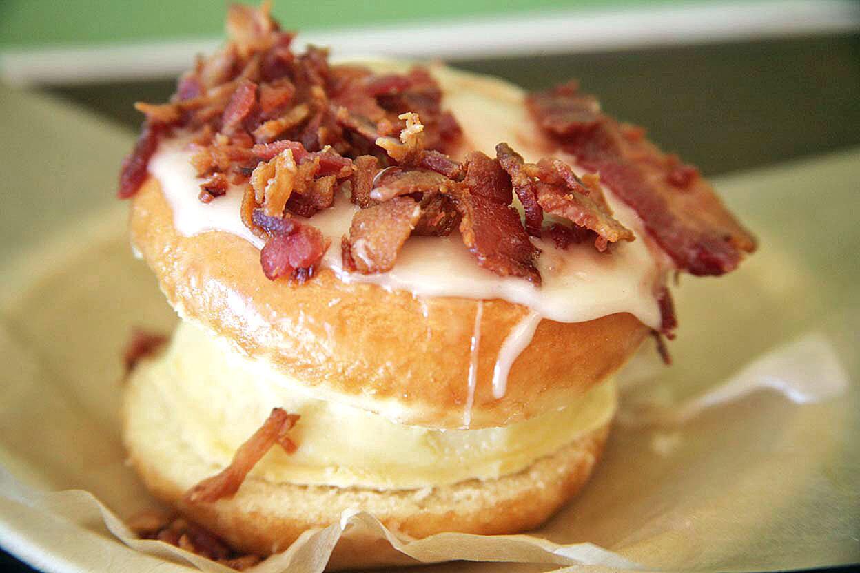 Everything is better with bacon. In this case, a traditional doughnut is made into a vanilla ice cream sandwich topped with vanilla glaze and bacon.