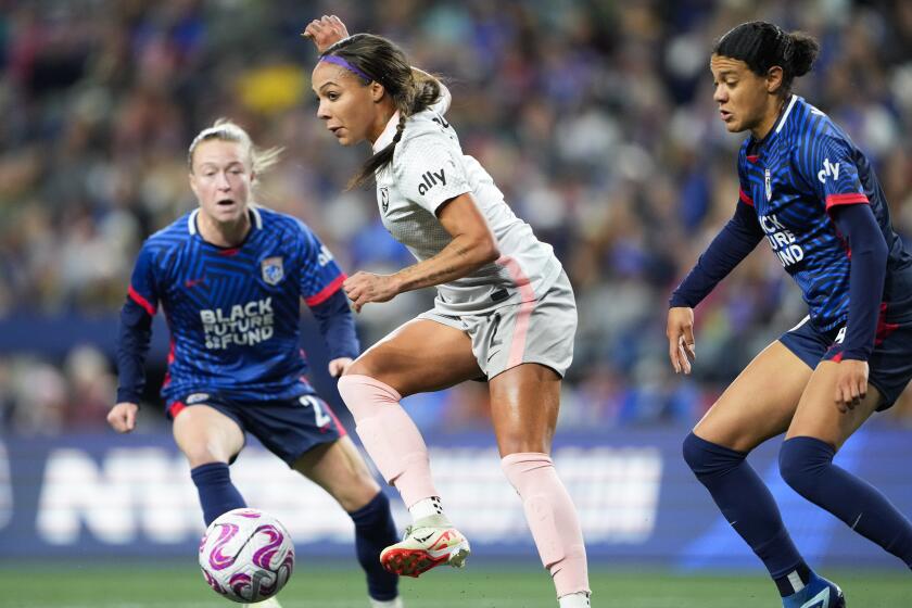 Angel City FC forward Sydney Leroux, center, makes a short pass in front of the goal.