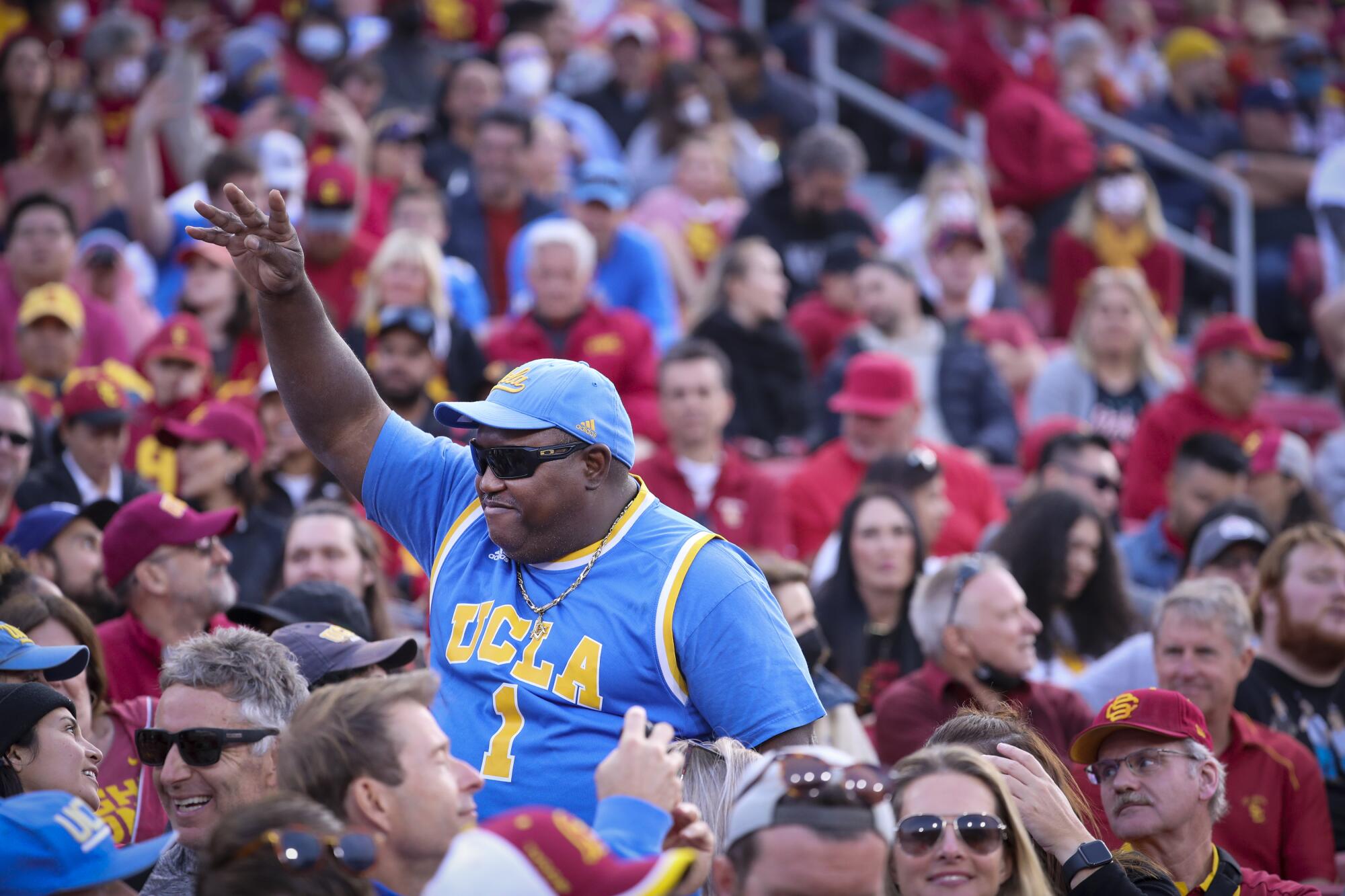 Surrounded by USC fans, a UCLA fan celebrates his team's looming victory.