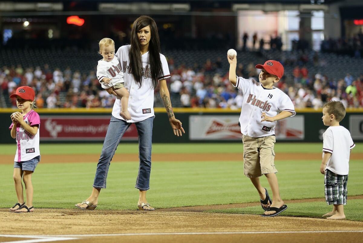 Juliann Ashcraft, wife of fallen Arizona firefighter Andrew Ashcraft, accompanies her children (from left to right) Shiloh, Choice, Ryder and Tate as they throw out the ceremonial first pitch before the start of Monday's Dodgers-Arizona Diamondbacks game.