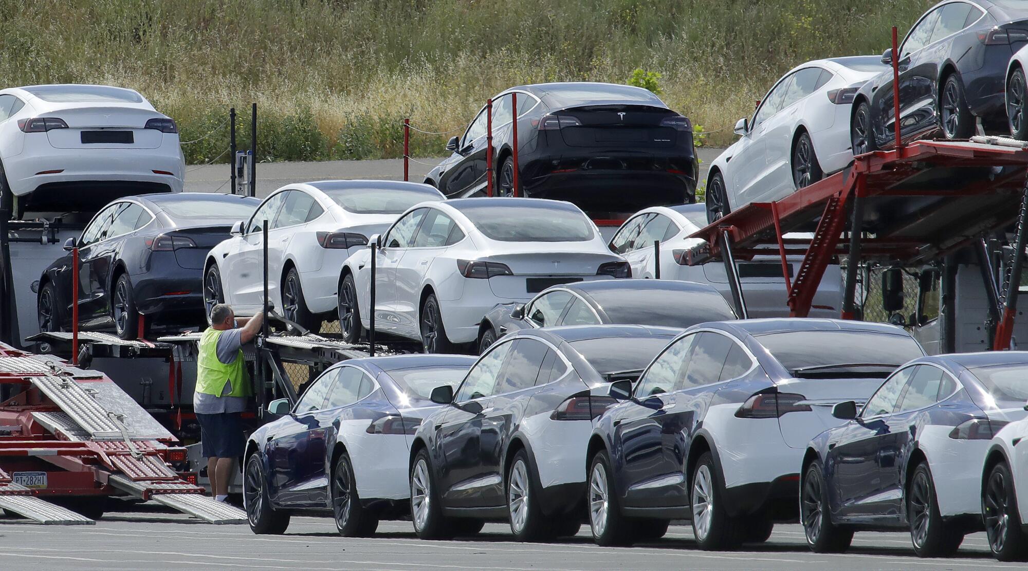 Tesla cars are loaded onto carriers at the Tesla electric car plant in Fremont, Calif.