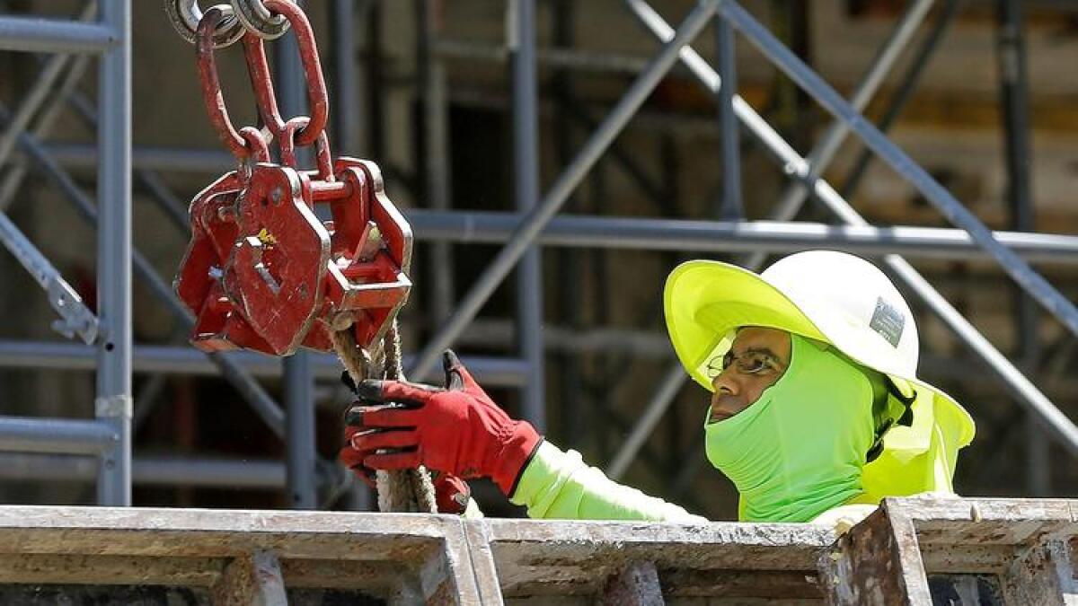 A construction worker pitches in at a condominium site in Coral Gables, Fla., in June.