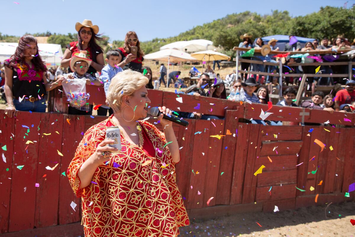 Towne, holding a beer given to her by an audience member, performs as Paquita la del Barrio inside a bullring at a festival in San Bernardino. 
