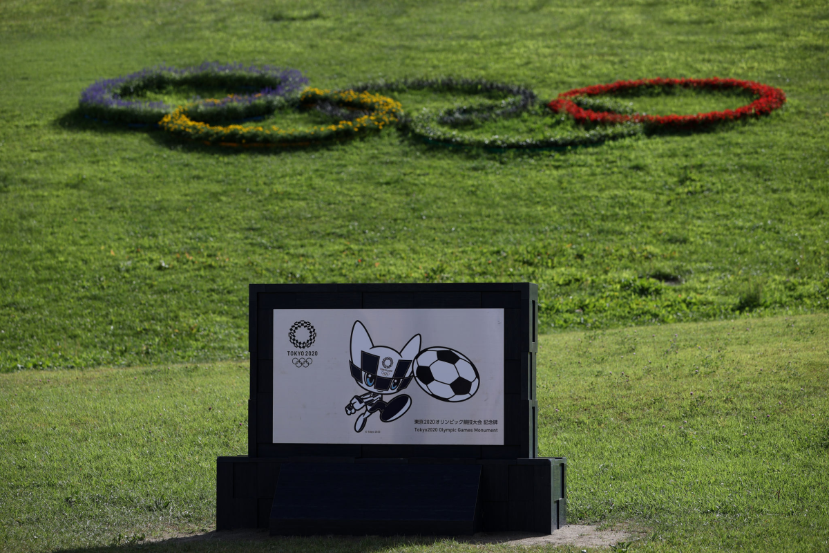 A black-and-white Olympic mascot kicks a soccer ball on a sign at the Tokyo Olympics.