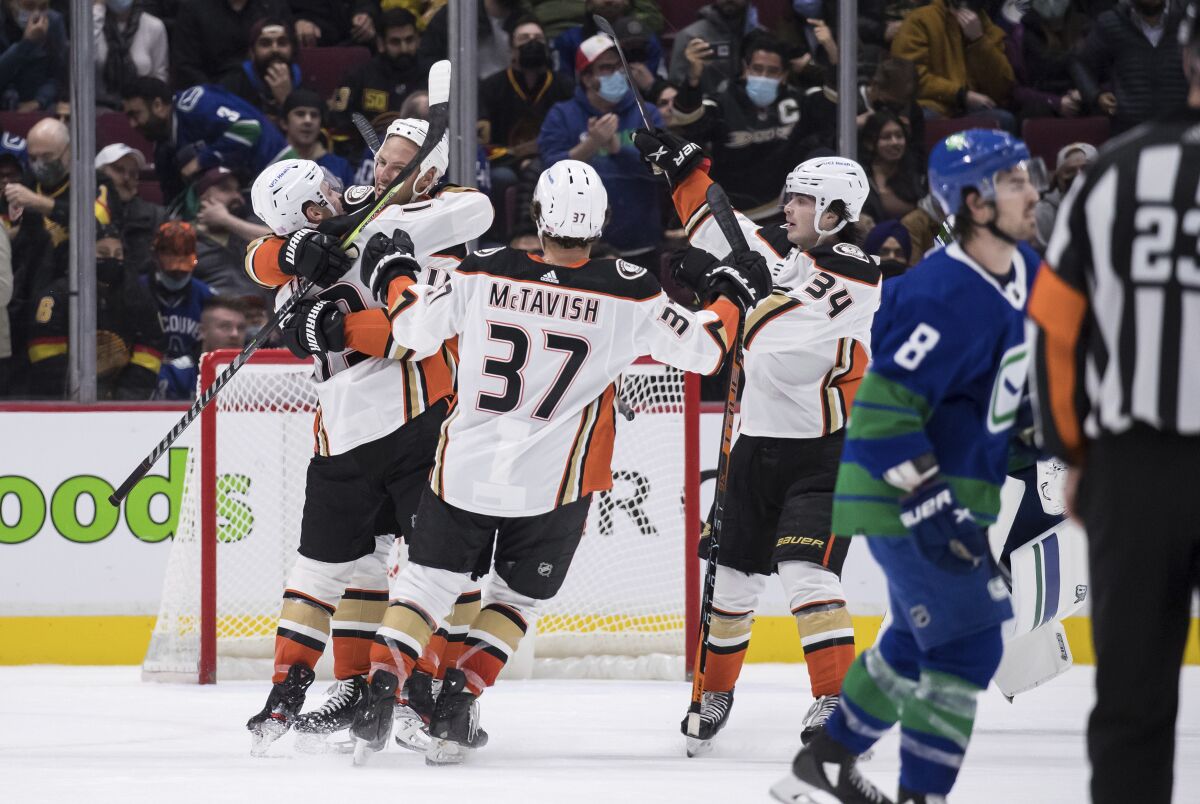 Anaheim Ducks' Troy Terry, Ryan Getzlaf, Mason McTavish and Jamie Drysdale, from left, celebrate Terry's overtime goal against the Vancouver Canucks in an NHL hockey game Tuesday, Nov. 9, 2021, in Vancouver, British Columbia. (Darryl Dyck/The Canadian Press via AP)
