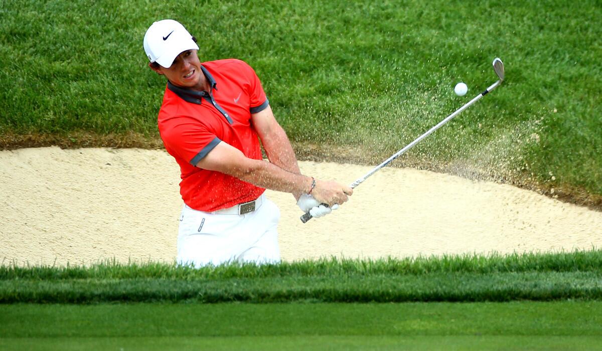 Rory McIlroy hits out of a bunker alongside the 17th green during the first round of the Memorial golf tournament on Thursday.