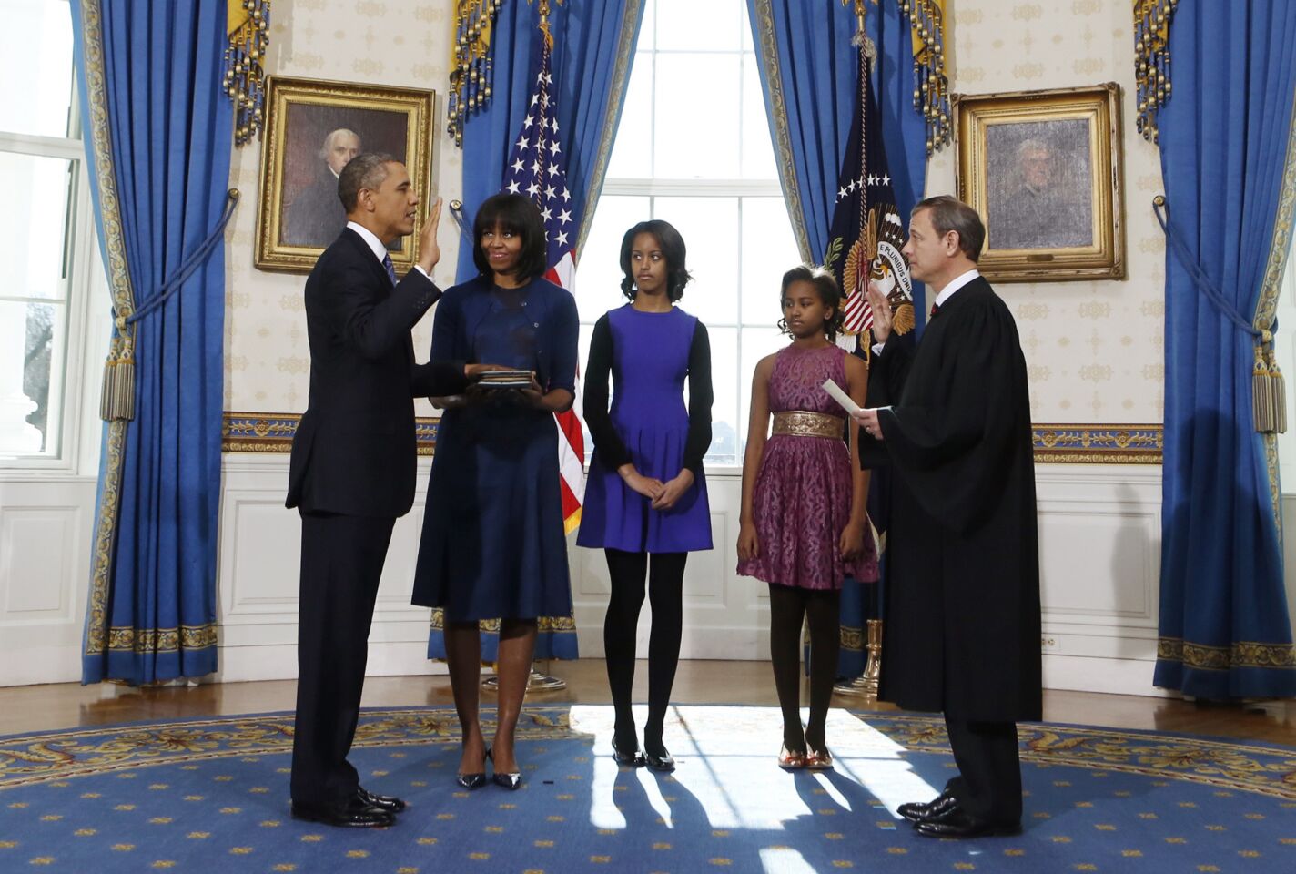 President Obama takes the oath of office from Chief Justice John G. Roberts Jr. in the company of First Lady Michelle Obama and their daughters Malia and Sasha in the Blue Room of the White House.