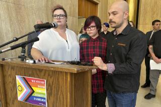 FILE - Parents Devon and Robert Dolney, of Fargo, N.D., stand with their 12-year-old child, Tate, center, during a news conference, Sept. 14, 2023, at the state Capitol in Bismarck, N.D. Tate Dolney is a transgender boy and a plaintiff in a lawsuit to block North Dakota's ban on gender-affirming care for minors. The law passed North Dakota's Republican-controlled Legislature overwhelmingly earlier this year. On Monday, Nov. 13, a North Dakota judge ruled that he won't immediately block the state's ban on gender-affirming health care for minors, delivering an early setback to the families and their pediatrician who want the new law found unconstitutional. (AP Photo/Jack Dura, File)