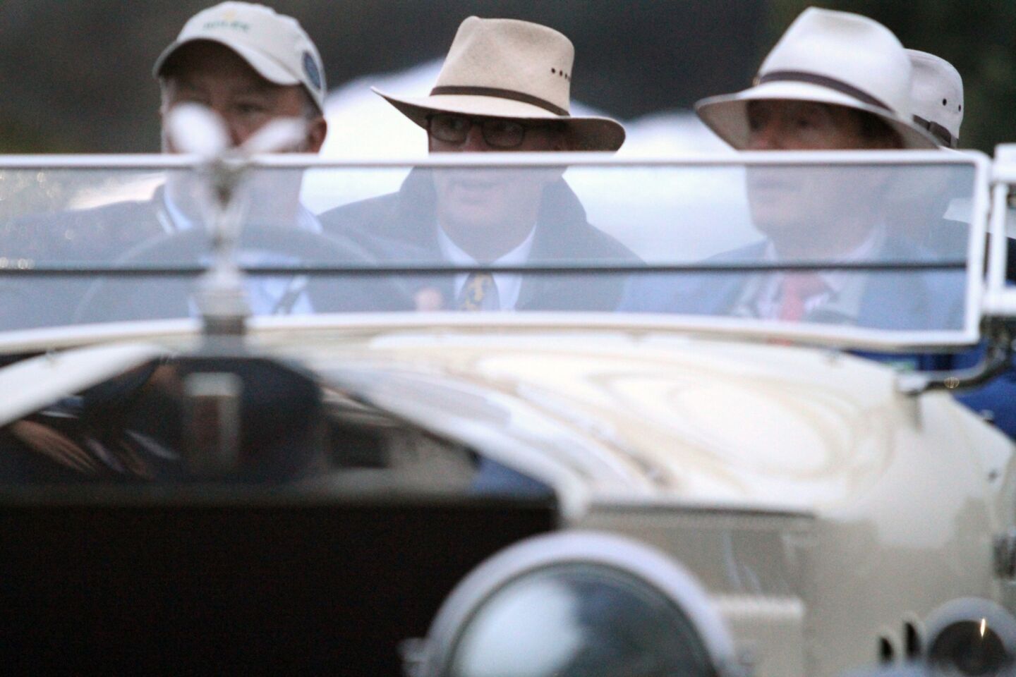 Wearing a variety of hats, contestants ride in their Rolls Royce.