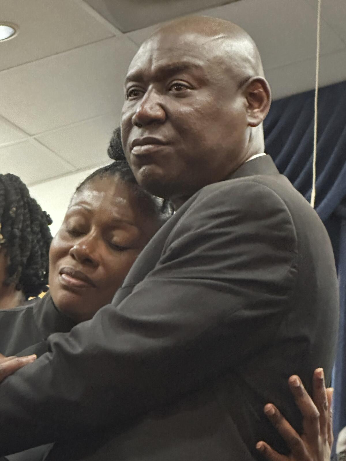 Attorney Ben Crump embraces Pamela Dias, the mother of Florida shooting victim Ajike Owens.