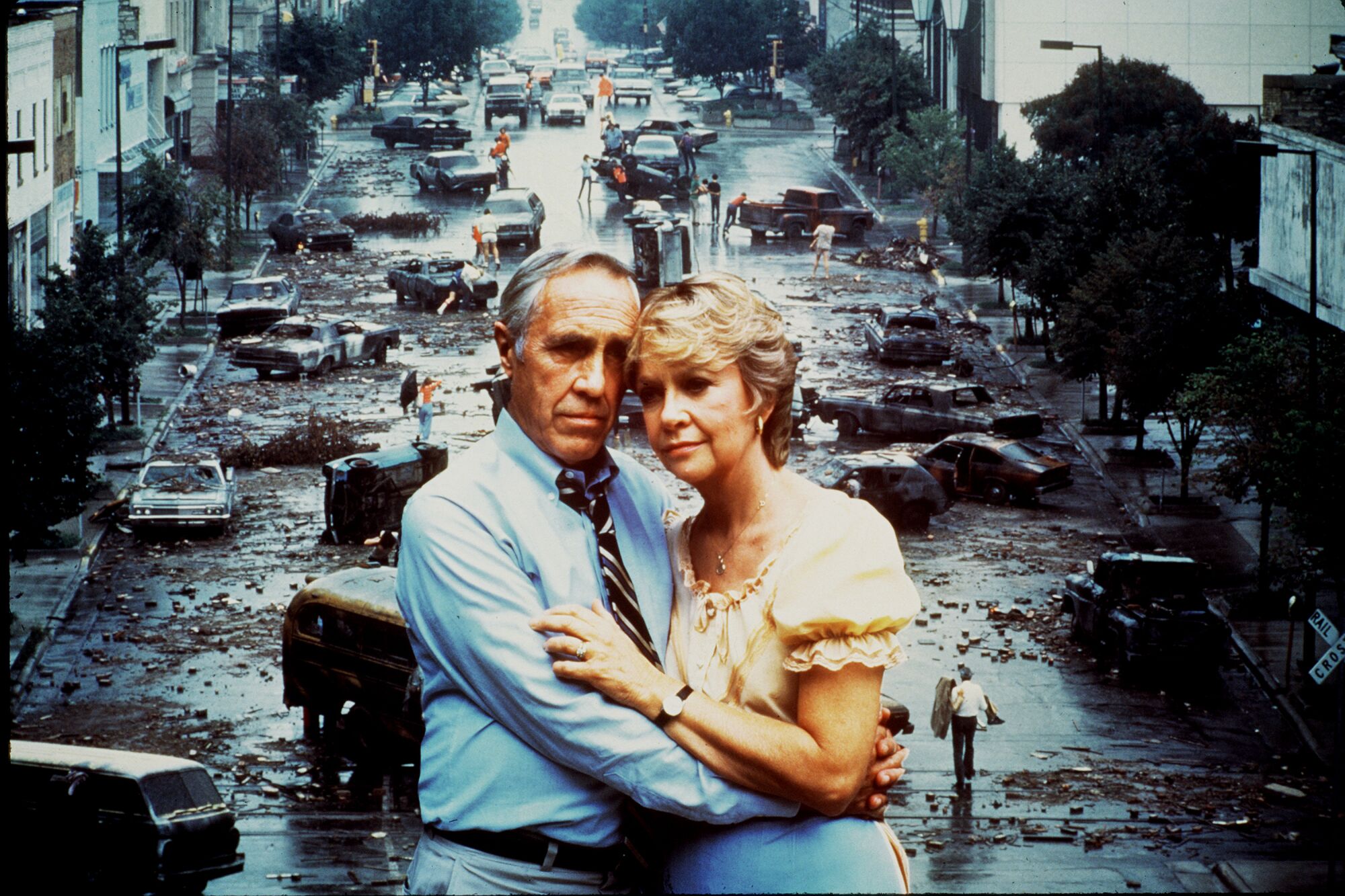 A photo illustration from "The Day After" shows actors Jason Robards and Georgann Johnson embracing before a devastated city.