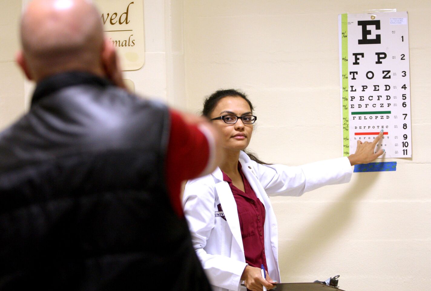 Kristen Omi, student at Southern California College of Optometry, right, gives a visual acuity test to an attendee at the Sixth Annual Glendale Health Festival at the Glendale Civic Auditorium in Glendale on Saturday, November 7, 2015.