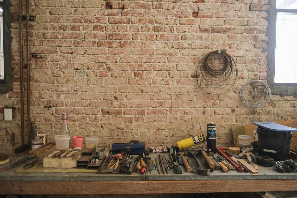 Glazing tools on a workbench against a brick wall at Luis Bermudez's studio.