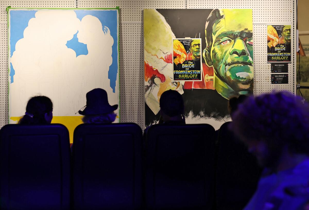 Guests wait to watch a live painting demonstration of "Bride of Frankenstein" in the "Rewind" exhibit at the O.C. Fair.