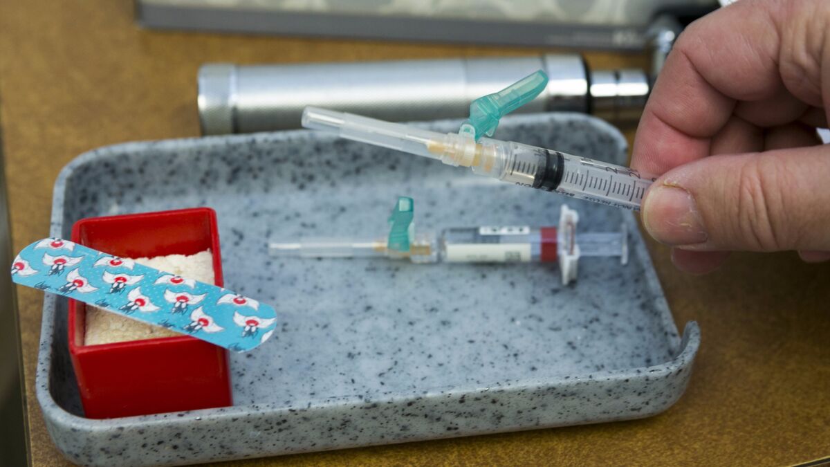 A dose of the vaccine against measles, mumps and rubella is readied for use.