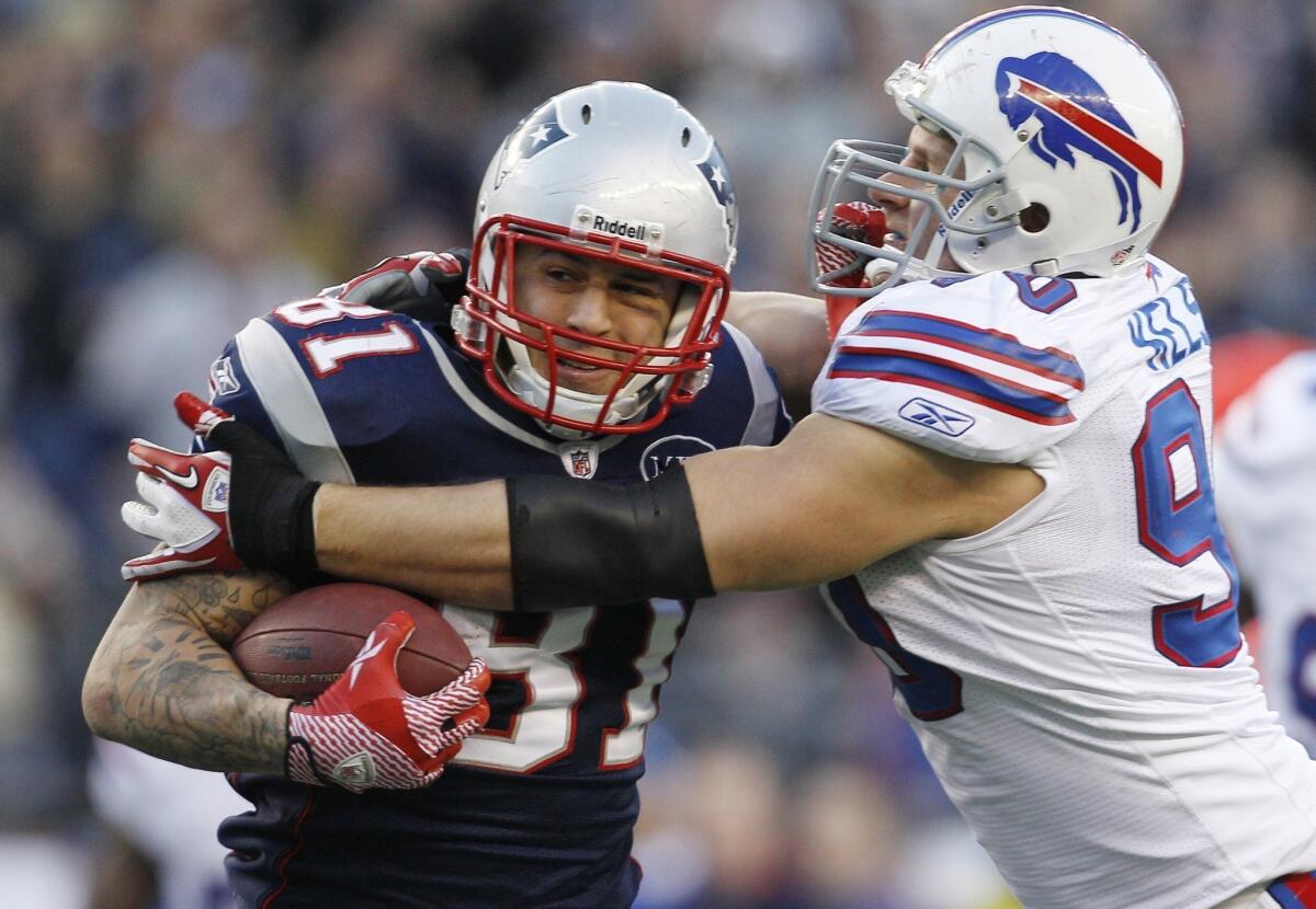 Tight end Aaron Hernandez, shown playing against Buffalo's Chris Kelsay in 2012, has been released by the New England Patriots after being taken from his home in handcuffs Wednesday morning.