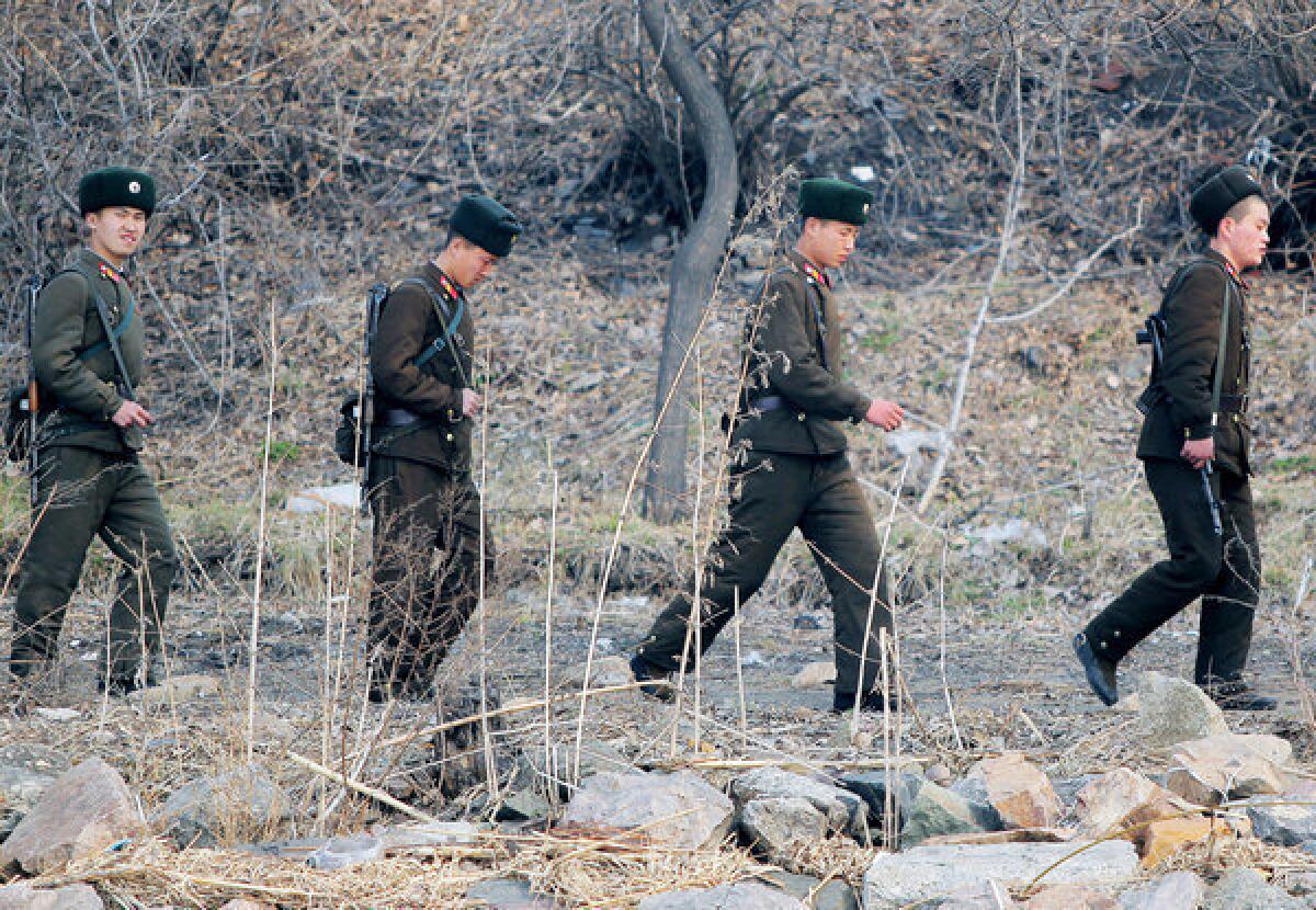 North Korean soldiers patrol along the bank of the Yalu River in the North Korean town of Sinuiju, across from the Chinese city of Dandong, on April 4, 2013.